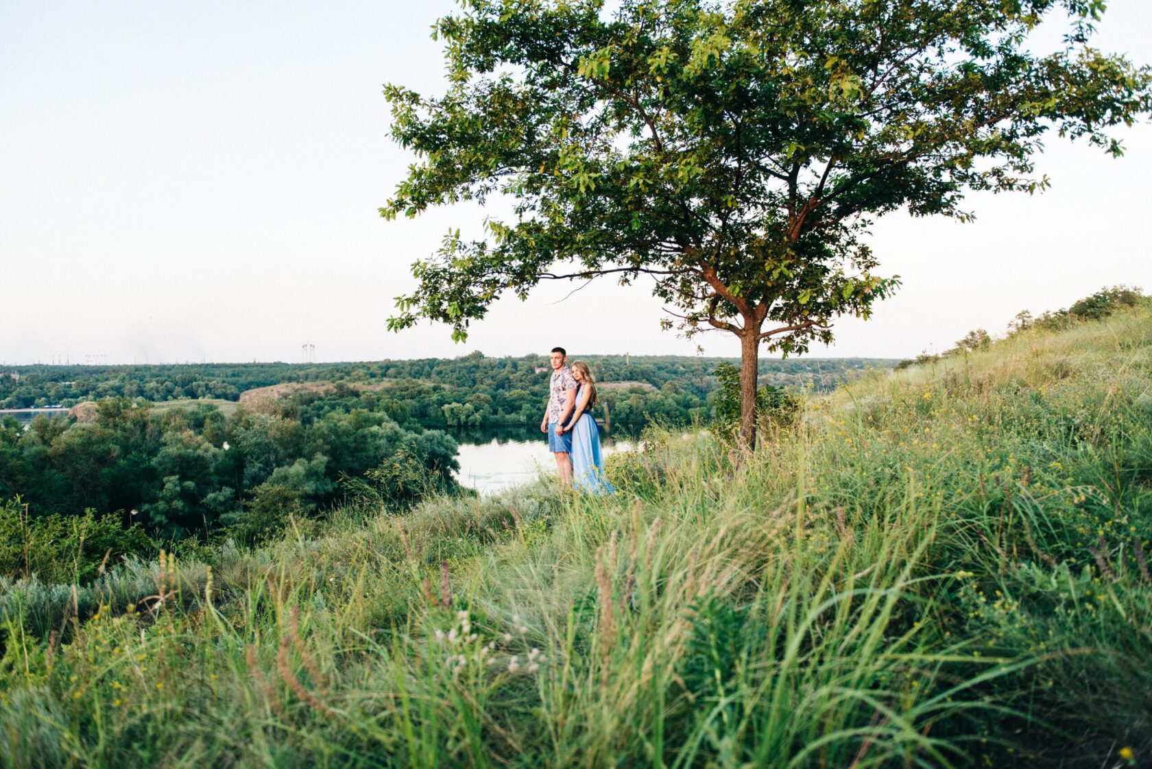 blonde girl with loose hair in a light blue dress and a guy in t